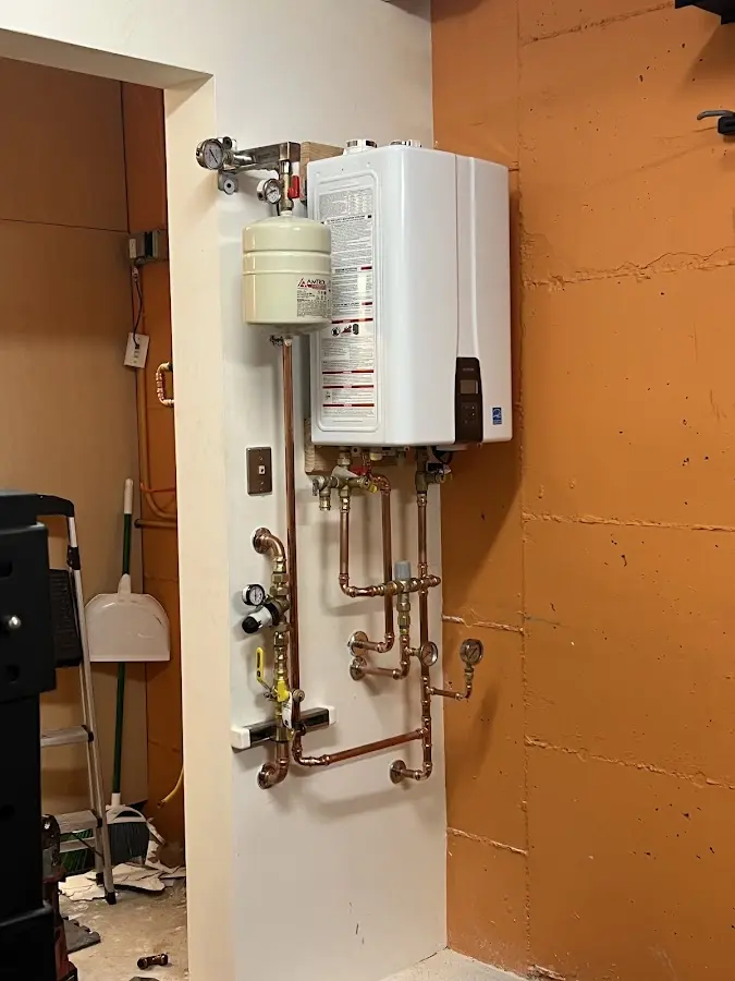 Plumbing technician inspecting water heater connections in Cleburne
